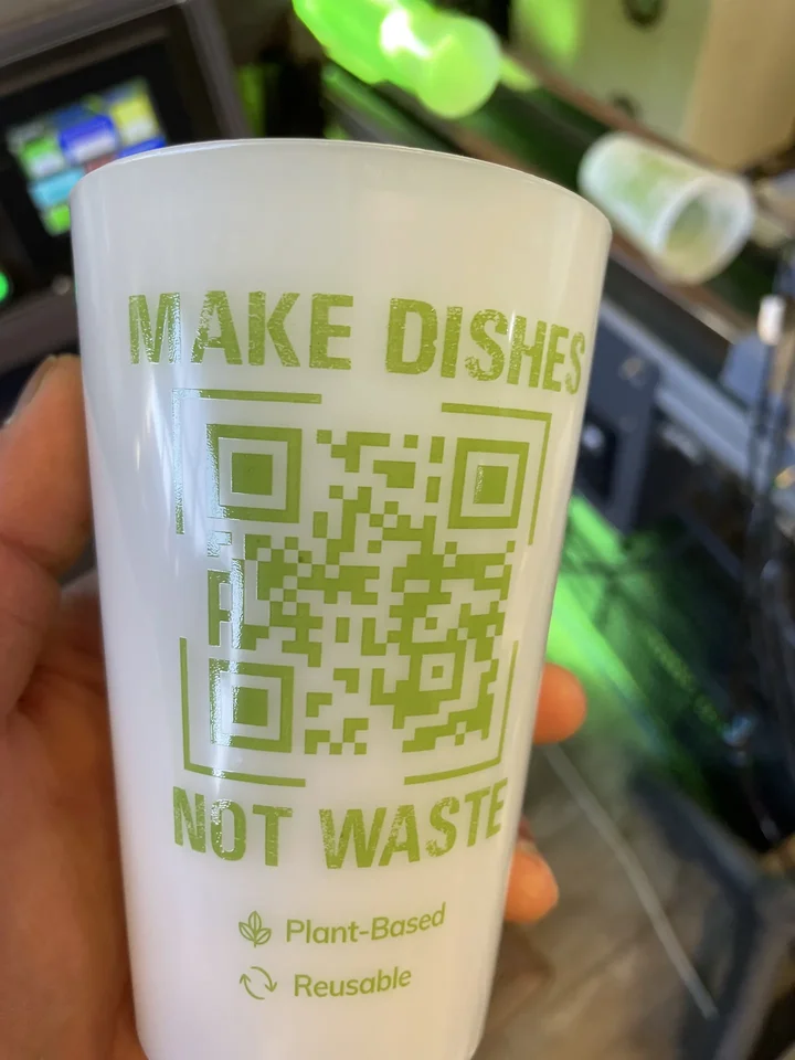 Reusable cup printed in green: Make dishes not waste, with a QR code